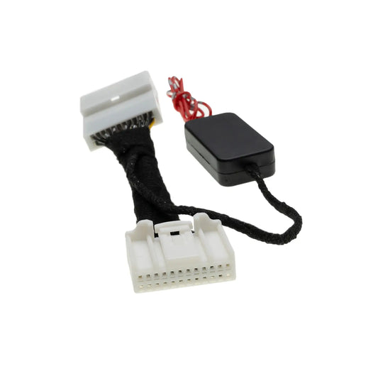 A black electronic module connected to a wrapped wire harness with two white multi-pin connectors, likely used for automotive or electronic system integration or modification.