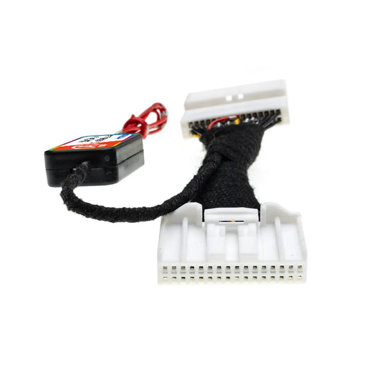 Close-up of an Idle Stop Disable Bypass device showing two white multi-pin connectors, braided wiring, and a compact control module with red wire for installation.