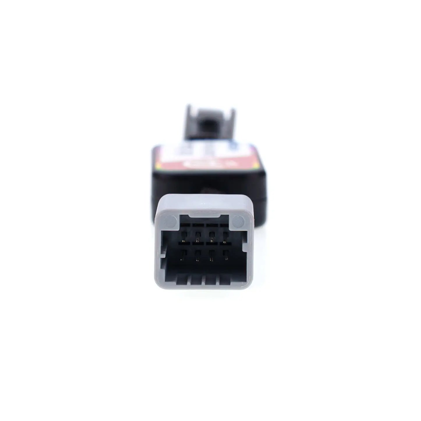 Close-up view of an automotive Idle Stop Disable Bypass device connector, showing a gray rectangular plug with multiple metal pins designed for easy vehicle system connection.