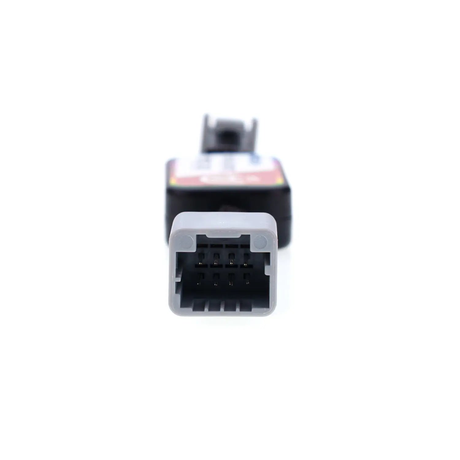 Close-up view of an automotive Idle Stop Disable Bypass device connector, showing a gray rectangular plug with multiple metal pins designed for easy vehicle system connection.