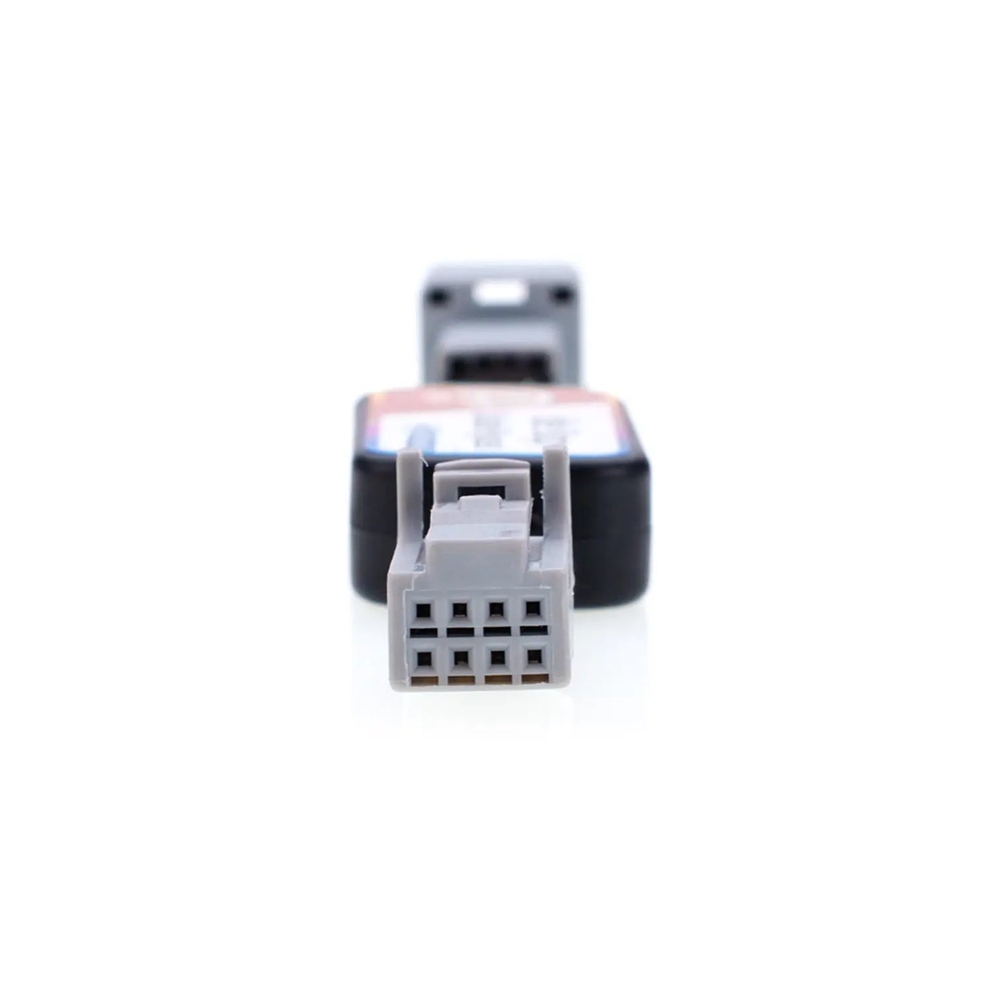 Close-up view of an automotive Idle Stop Disable Bypass device connector, showing a gray rectangular plug with multiple metal holes designed for easy vehicle system connection.