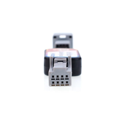 Close-up view of an automotive Idle Stop Disable Bypass device connector, showing a gray rectangular plug with multiple metal holes designed for easy vehicle system connection.